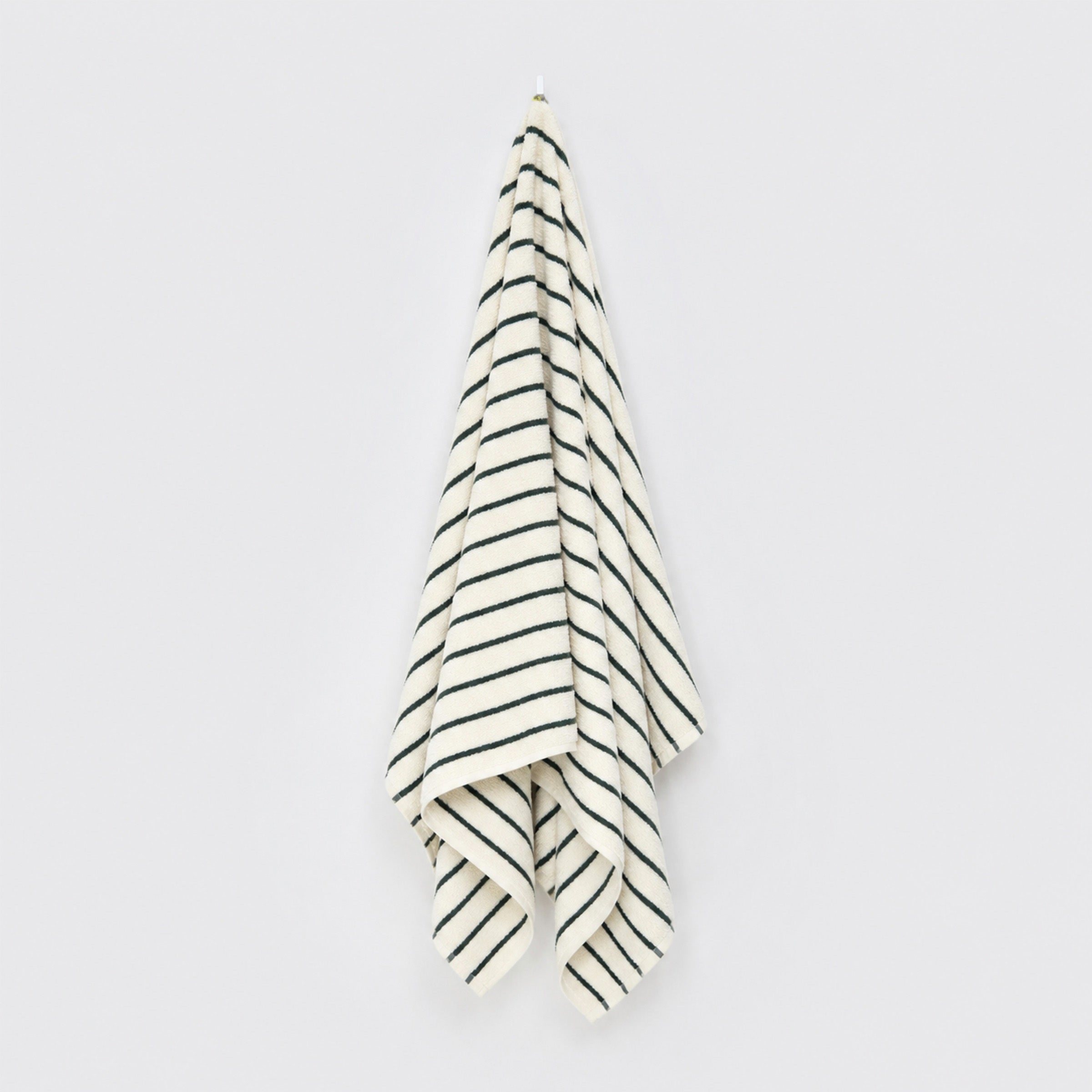 organic-cotton-bath-towel-in-forest-pinstripes-colour-hanging-on-a-wall-by-sojao